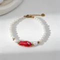 Gros plan sur un bracelet en perles fait main avec un charme de poisson rouge. - Bracelet à Maillons en Acier Inoxydable / Chaîne Perle Poisson Rouge