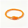 Vue détaillée d'un bracelet en perles orange avec un charm poisson et des perles dorées - Petit Poisson Orange