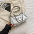 Silver metallic shoulder bag with chain strap and heart clasp, trendy faux leather baguette style. - Silver