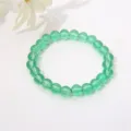 Makroansicht von 8mm transparenten grünen Glasperlen auf einem Stretch-Armband mit Glanzfinish - Transparent Grass Green