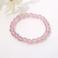 Detailansicht eines 8 mm großen, rosa, durchscheinenden Glasperlenarmbands auf Weiß. - Transparentes Rosa
