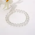 Nahaufnahme eines klaren, transparenten 8-mm-Glasperlenarmbands auf weißem Grund. - Klarweiß