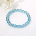 Nahaufnahme eines 8 mm großen transparenten blauen Glasperlenarmbands auf weiß - Transparentes Himmelblau