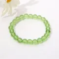 Detaillierte Nahaufnahme eines 8 mm transparenten hellgrünen Glasperlenarmbands für Damen - Transparentes Grün