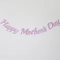 Pink glitter Happy Mother's Day banner hanging decoration detail shot for holiday party setup. - Glitter Pink Mother's Day Banner