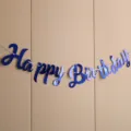 Blue happy birthday banner hanging on the wall, perfect party decoration detail shot. - New Script Birthday Blue Banner
