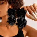 Detailed view of oversized black fabric flower dangle earrings worn by a model - Black Two Flowers