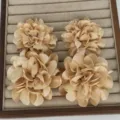 Elegante champagnerfarbene Stoffblumen-Ohrringe auf einem Samt-Schmuckdisplay - Champagner Zwei Blüten
