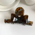 Tortoiseshell bow hair claw clip detail shot, elegant cellulose acetate hair accessory closeup. - Blue Brown