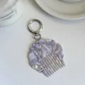 Detail view of the portable acetate shell comb keychain with a chic pearlescent marble finish. - Approx. 6.4cm*6.4cm / Textured Purple