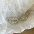 Primo piano dettagliato di fermagli per capelli con ali d'angelo in strass brillanti. - Clip Paio Ali D'Angelo / Set da 2 Pezzi / Bianco