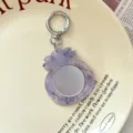 Vista dettagliata del portachiavi con mini specchio testurizzato vintage per borsa. - Viola