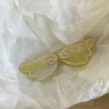 Close-up detail of the rhinestone angel wings hair clip, sparkling crystal details on acetate. - Angel Wing Pair Clips / 2 Pieces/Set / Yellow
