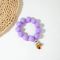Gros plan d'un bracelet d'Halloween en perles acryliques mauves avec pendentif tête de mort - Bracelet Plaque Crâne / 5.5cm Diamètre Intérieur / Violet (S-003)