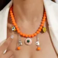 Gros plan macro détaillé d'un collier d'Halloween en perles orange avec breloques citrouille - Œil Orange (N-005)