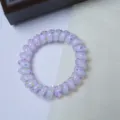 Detailed view of the cute purple telephone wire hair tie with colorful polka dot accents. - Coconut Polka Dot Spiral Ring / Purple