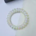 Close-up detail of translucent white telephone wire hair tie with colorful polka dot accents. - Coconut Polka Dot Spiral Ring / Light Yellow