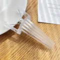 Transparent bangs clip detail showing clear plastic structure and metal spring design. - Clear