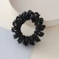 Vista dettagliata di un elastico per capelli a spirale nero, che mostra la struttura intrecciata. - Elastici a spirale in corda nera #6