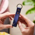 Gedetailleerd overzicht van de lederen telefoonhouder sleutelhanger, stijlvol accessoire. - Blauw