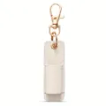 Detalle de primer plano del bolsillo portalápices de cuero blanco con llavero dorado. - Blanco