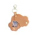 Detalle de llavero conmemorativo de mascota en cuero marrón, forma de pata bonita con ventana. - Tostado