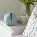 Close-up van lichtblauwe wafel gewatteerde cosmetictas in esthetische slaapkamer. - Lichtblauw