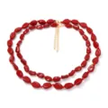 Dettaglio della elegante collana di perle rosse ovali e irregolari a doppio strato per donna. - Borgogna