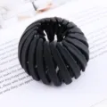 Close-up of a black expandable bird's nest hair clip, perfect for stylish lazy ponytails. - Bird's Nest Scrunchie / Black