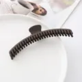 Nahaufnahme der dunkelbraunen, matten Haarklammer mit rutschfestem Design für sicheren Halt. - Braun