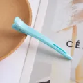 Detailed close-up of a light blue duckbill hair sectioning clip, showing spring and texture. - [Light Blue] Professional Hair Styling
