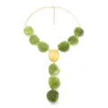 Vista di dettaglio della collana vintage con perline verdi e pendente ovale dorato. - verde-giallo