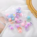 Vista dettagliata di mini elastici per capelli colorati con pon-pon in peluche per bambini. - Serie pompon macaron