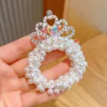 Close-up detail of a charming children pearl hair scrunchie with rhinestone crown decor. - Princess Crown Hair Tie #4
