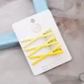 Ensemble de trois pinces à cheveux en métal jaune, jolies barrettes croisées sur carte blanche. - Ensemble de 3 pièces croisées jaune