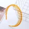 Close-up view of the yellow wavy hair headband with teeth, showcasing its anti-slip design. - Toothed Headband / Yellow