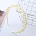 Gedetailleerde close-up van de antislip kunststof haarband met zijn unieke getande structuur. - Getande Hoofdband / Beige