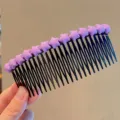Close up detail of black plastic hair comb decorated with purple star elements for styling. - Large Purple Star Hair Side Comb