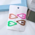 Vista dettagliata di mollette per capelli a cuore color caramella, set da 4 su cartoncino. - Cuori (Marrone e verde - 4 pzs/cartoncino)