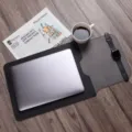 Detail shot of PU leather laptop sleeve and folding desk mat on wood table with office props. - 16" / Black