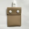 Close-up of portable pacifier storage bag with snap buttons and clip, detail view. - Khaki