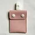 Portable pink PU leather baby pacifier pouch featuring white clip and dual snaps for stroller. - Pink