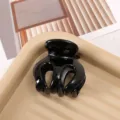 Detail shot of black hair claw clip, glossy plastic finish, minimalist aesthetic background. - 5cm / Black