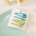 Detailed close-up view of cute colorful wave hair clips and snap clips set on card. - Green 4-Piece Set