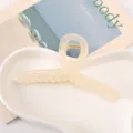 Close-up van doorschijnende acryl haarhaarklem met kruisontwerp op witte schaal. - 13cm / Broken Wit