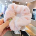 Vista dettagliata di un morbido scrunchie per capelli rosa, perfetto accessorio invernale. - Rosa