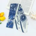 Detail shot of blue and white toile de jouy print twilly scarf with elegant French text. - Robin Satin Scarf