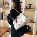 Detail view of cute white corduroy cherry print tote bag with chic silk scarf accessory. - White Cherry