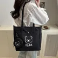 Detail shot of the black canvas tote bag featuring cute bear print and matching coin purse. - Black
