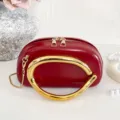 Red mini crossbody bag featuring an oversized gold arch metal handle and chic chain strap. - Red